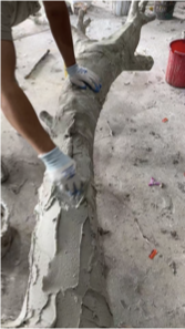 Hand sculpting texture on an artificial tree trunk